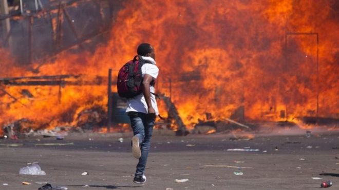 An opposition supporter runs during a protest in Harare, Zimbabwe. Photo: 26 August 2016