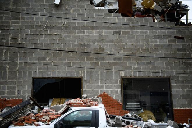 A truck is seen below a partial collapsed wall after Hurricane Michael in Panama City, Florida, 10 October 2018