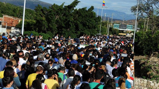 Венесуэльцы ждут в Сан-Антонио-де-Тачира, Венесуэла, чтобы пересечь границу с Колумбией 10 июля