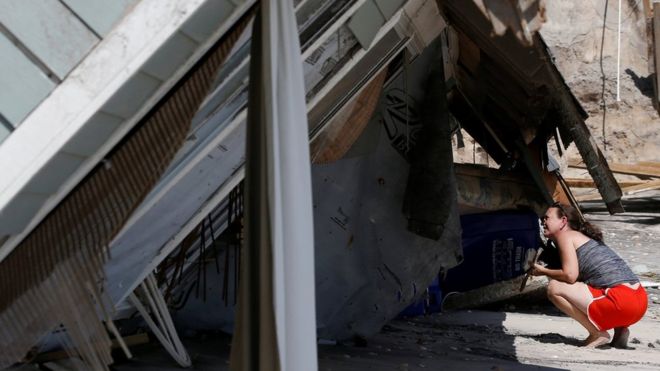 Местный житель заглядывает в рухнувший прибрежный дом после того, как ураган Ирма обошел территорию в Вилано-Бич, штат Флорида