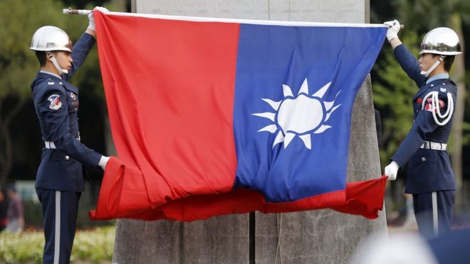 Тайваньские почетные караулы держат тайваньский флаг в Мемориальном зале Сунь Ятсена в Тайбэе, Тайвань