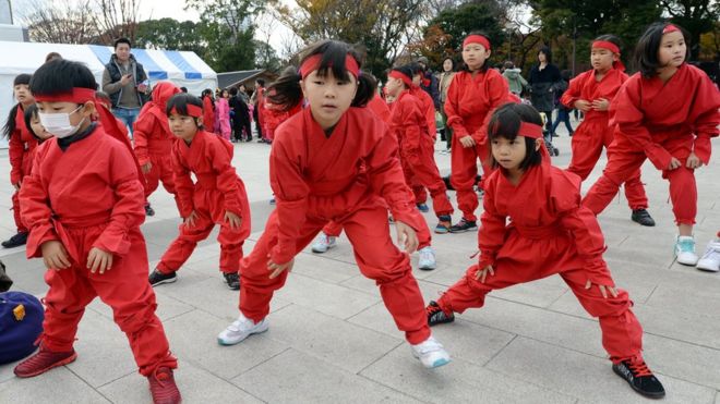 Разогрев детей в костюме ниндзя для танцевального представления на тему ниндзя в Ига, префектура Миэ