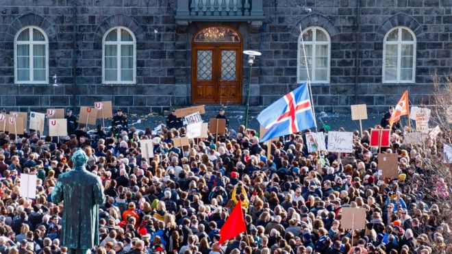 Люди собираются во время акции протеста на площади Austurvollur перед зданием исландского парламента в Рейкьявике, Исландия, 4 апреля 2016 года