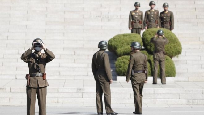 Северокорейский солдат смотрит в бинокль в сторону Южной Кореи