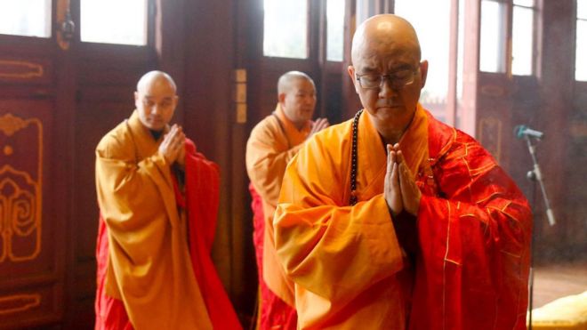 На этой фотографии, сделанной 12 февраля 2016 года, изображен Сюэчэн (справа), настоятель пекинского монастыря Лунцюань, молящийся во время церемонии