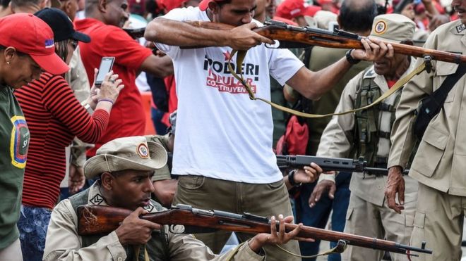 Civiles sin uniformes y milicianos disparando.