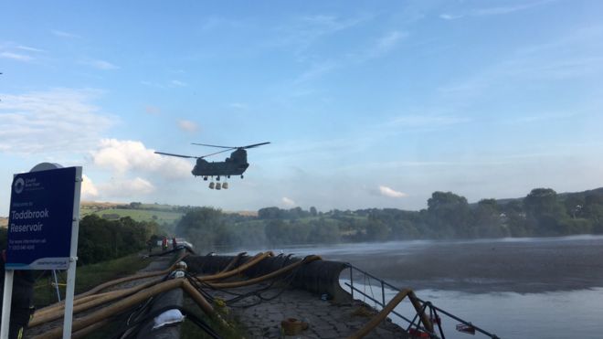 Helicopter flies over reservoir