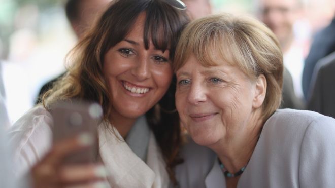 Канцлер Меркель (справа) позирует для селфи в Болдекове, 18 августа 16