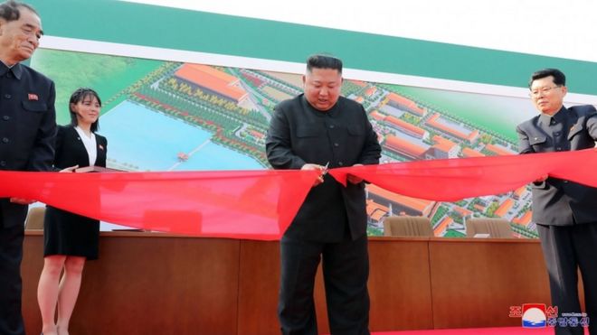 Kim Jong-un cortando la cinta de una fábrica.