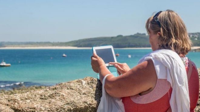 Женщина на пляже с планшетом