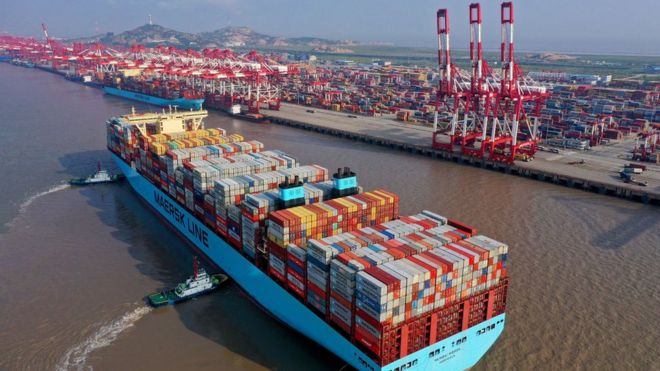 Tugboats guide a container ship of Maersk Line at the Yangshan Deepwater Port