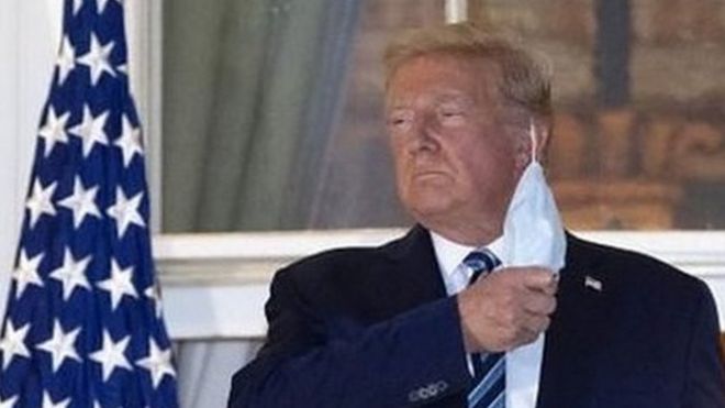 Donald Trump takes off his mask on White House balcony.
