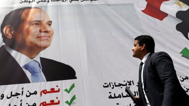 مصري يمر أمام لافتة لدعم السيسي
