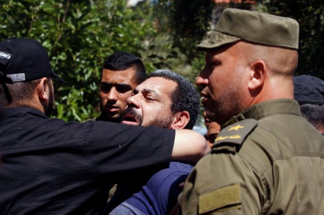 Members of Palestinian security forces loyal to Hamas escort a prisoner in Gaza City, 21 May