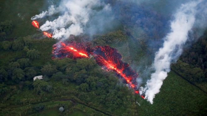 Лава извергается из трещины к востоку от подразделения Лейлани Эстейтс во время продолжающихся извержений вулкана Килауэа на Гавайях 13 мая 2018 года.