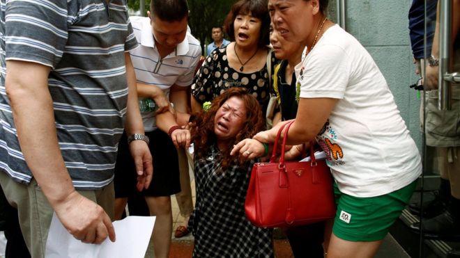 Член семьи пассажира рейса MH370 авиакомпании Malaysia Airlines, пропавшего в 2014 году, реагирует на акцию протеста перед министерством иностранных дел Китая в Пекине, 29 июля 2016 года