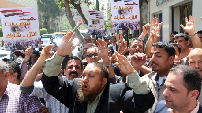 ناخبون يحملون لافتات كُتب عليها "انزل... شارك"