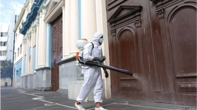 Sanitation worker spraying the streets in a town in Ecuador