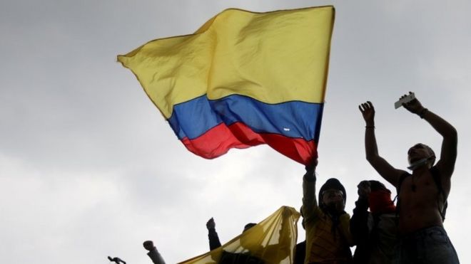 Manifestantes con la bandera de Colombia