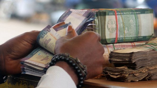 Hands counting money in Liberia