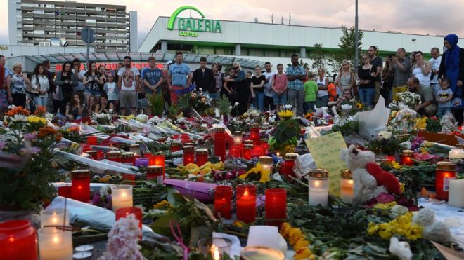 Свечи и цветы вне сцены стрельбы в Мюнхене. 24 июля 2016 года