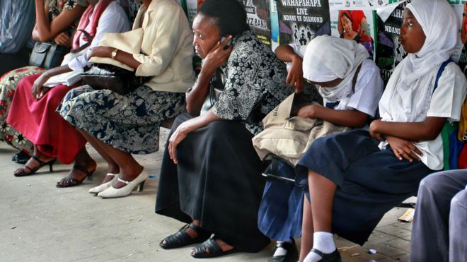 Люди ждут на скамейке в Дар-эс-Саламе, Танзания