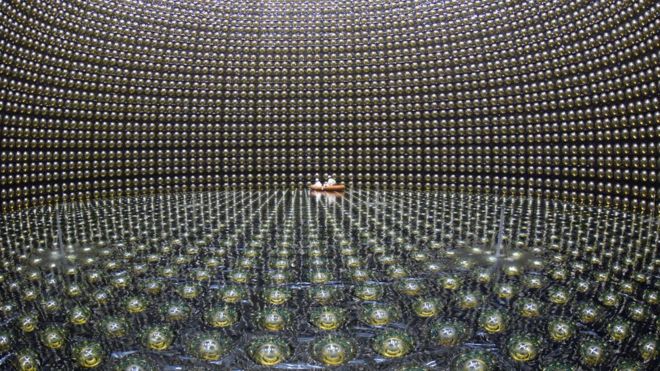 workers on an inflatable raft inside a huge neutrino observatory