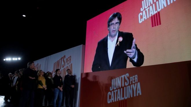 Ousted Catalan leader Carles Puigdemont appears on a screen during an event of his political platform "Junts per Catalunya" to mark the official start of the electoral campaign