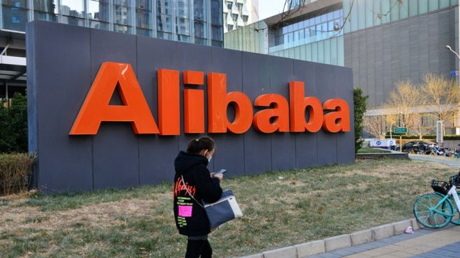 Una mujer frente a un anuncio de Alibaba