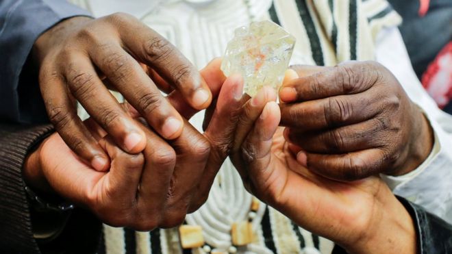 People from Sierra Leone hold the 709-carat diamond in New York, 21 November 2017