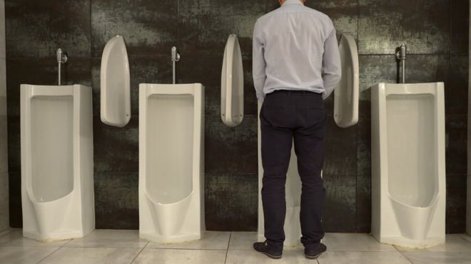 Homem urinando em mictório
