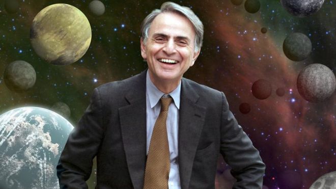 Carl Sagan con ilustración de planetas detrás suyo.
