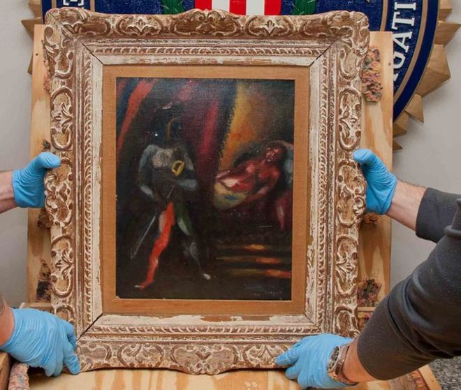 The FBI's Art Crime Team hold a framed work by Marc Chagall prior to its return to the owners' estate nearly 30 years after it was stolen.