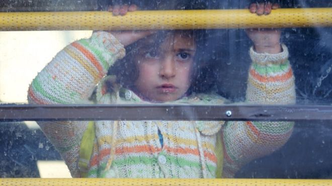 A Syrian girl rides a bus towards the Turkish border