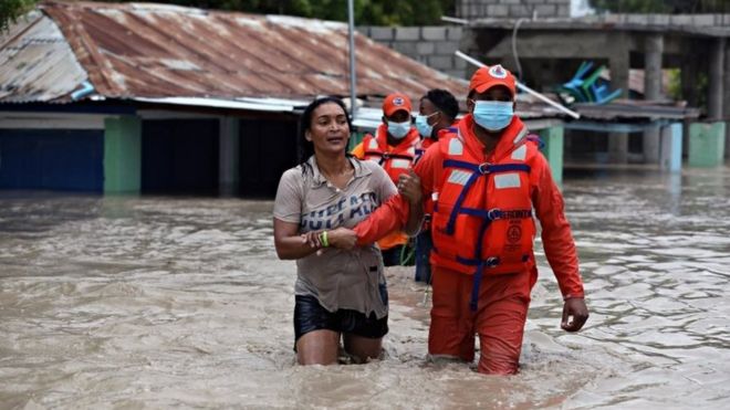 La defensa civil de República Dominicana rescata a una mujer tras las inundaciones causadas por la tormenta Laura.