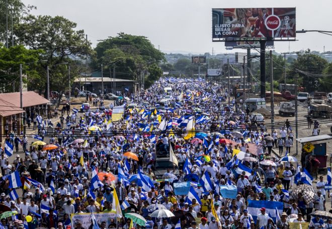 Тысячи никарагуанцев прошли в знак протеста против гибели студентов во время полицейских репрессий.Этот марш состоялся в Манагуа в апреле 2018 года