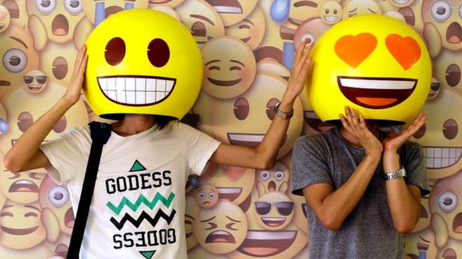 Dos personas probándose unas "máscaras" de emojis en China