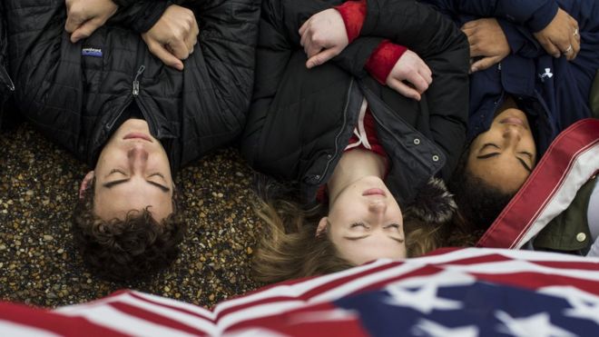 銃規制強化を求め、ホワイトマウス前で死体を模して横たわり抗議する若者たち（19日、ワシントン）
