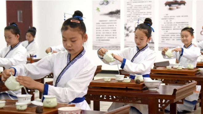 Niñas asiáticas practican el ritual del té
