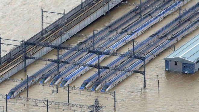 Этот вид с воздуха показывает затопленное депо со сверхскоростными поездами синкансэн в Нагано, префектура Нагано