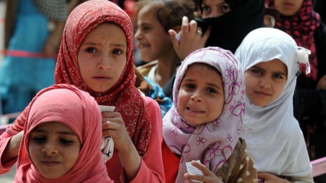 نساء وفتيات يمنيات تضررن بالحرب يقفن في طابور لاستلام المساعدات من جمعية خيرية