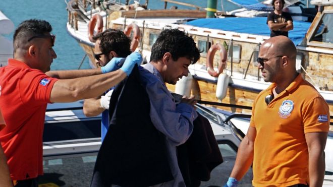 Paramedics escort migrants after being rescued at the port of Mytilene on the island of Lesbos, Greece, 13 July