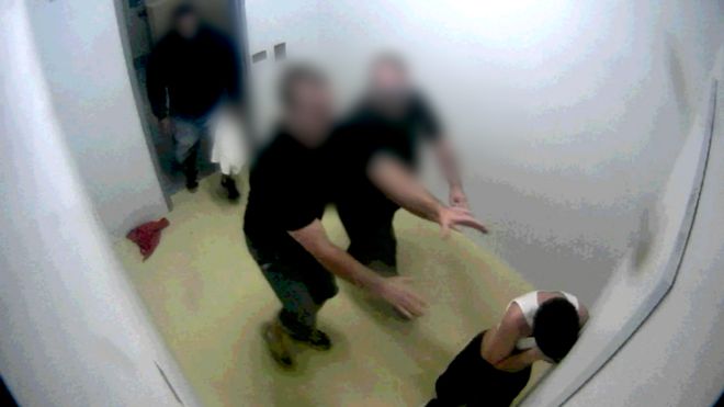 Молодого заключенного насильно раздевают тюремные охранники