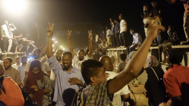 Толпы людей, пересекающих мост, идут на сидячую забастовку в военном штабе в Хартуме, Судан, понедельник, 8 апреля 2019 года