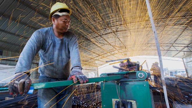 Работник разрезает стальные прутья на строительной площадке железнодорожного моста в Ляньюньгане, провинция Цзянсу, Китай