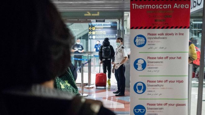 Чиновники общественного здравоохранения проводят тепловое сканирование пассажиров, прибывающих из Ухани, Китай, в аэропорту Суварнабуми 8 января 2020 года в Бангкоке, Таиланд