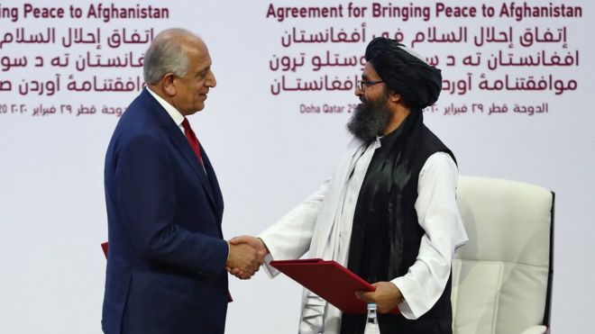 El representante especial de Estados Unidos para la reconciliación en Afganistán, Zalmay Khalilzad, da la mano al cofundador del Talibán, Mullah Abdul Ghani Baradar, durante la ceremonia de la firma del acuerdo en Qatar.