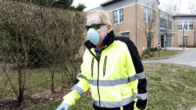 Nicholas Walsh, of New Rochelle, wears a protective mask as he walks past the Young Israel of New Rochelle synagogue (R) in New Rochelle, New York, USA, 10 March 2020.