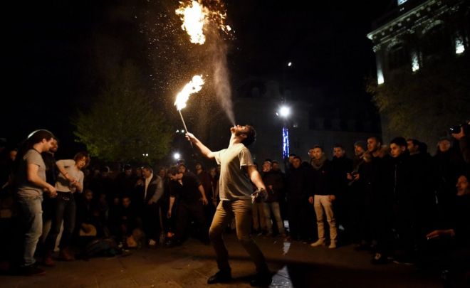 Пожиратель огня выступает во время собрания «Nuit Debout» 17 апреля в Париже
