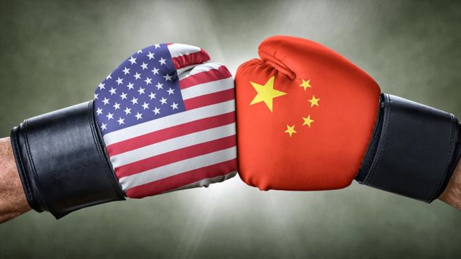 Dos puños enfrentados con las banderas de EE.UU. y China.